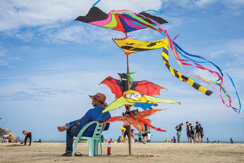 A kite merchant displays his wares to the perfect backdrop