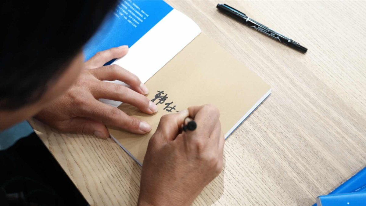 Han signs a copy of her poetry collection for a reader, female poet in rural china