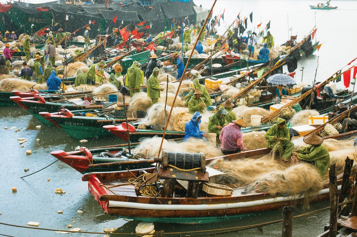 Fishing families mend their nets before the start of fishing season