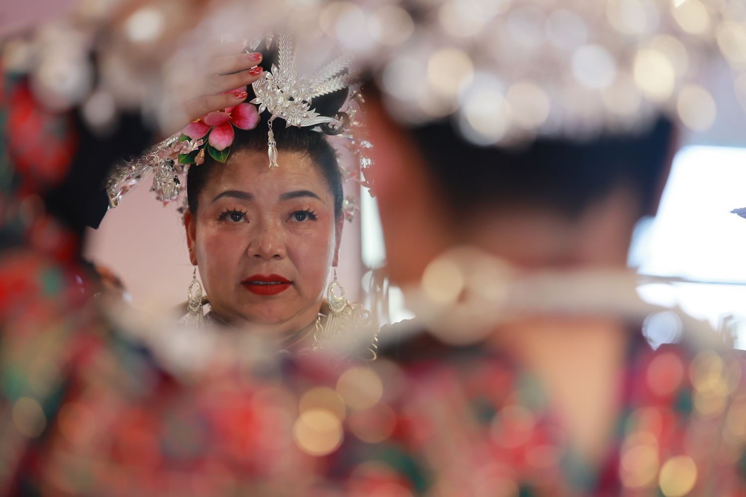 A villager prepares her make-up and accessories before going on the stage