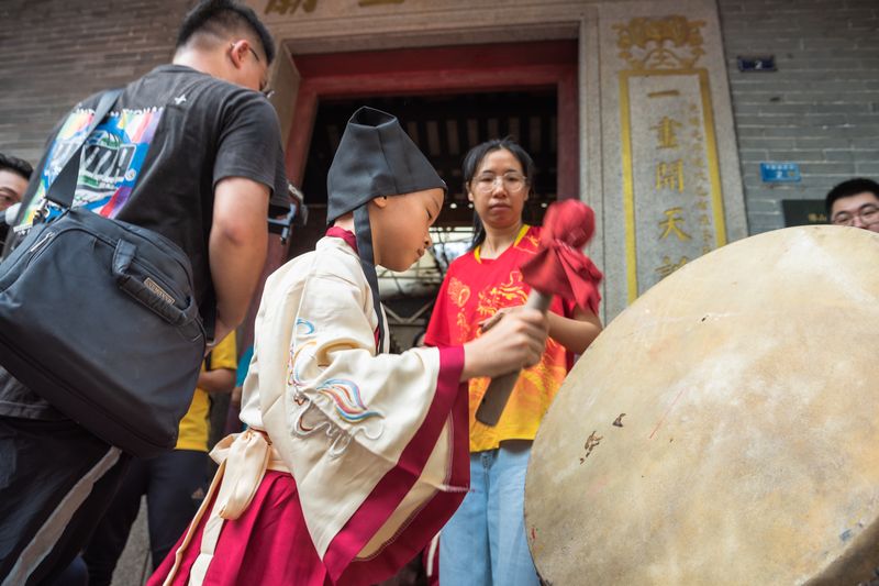 Students beat a drum at the gate of the temple to show their determination to study hard