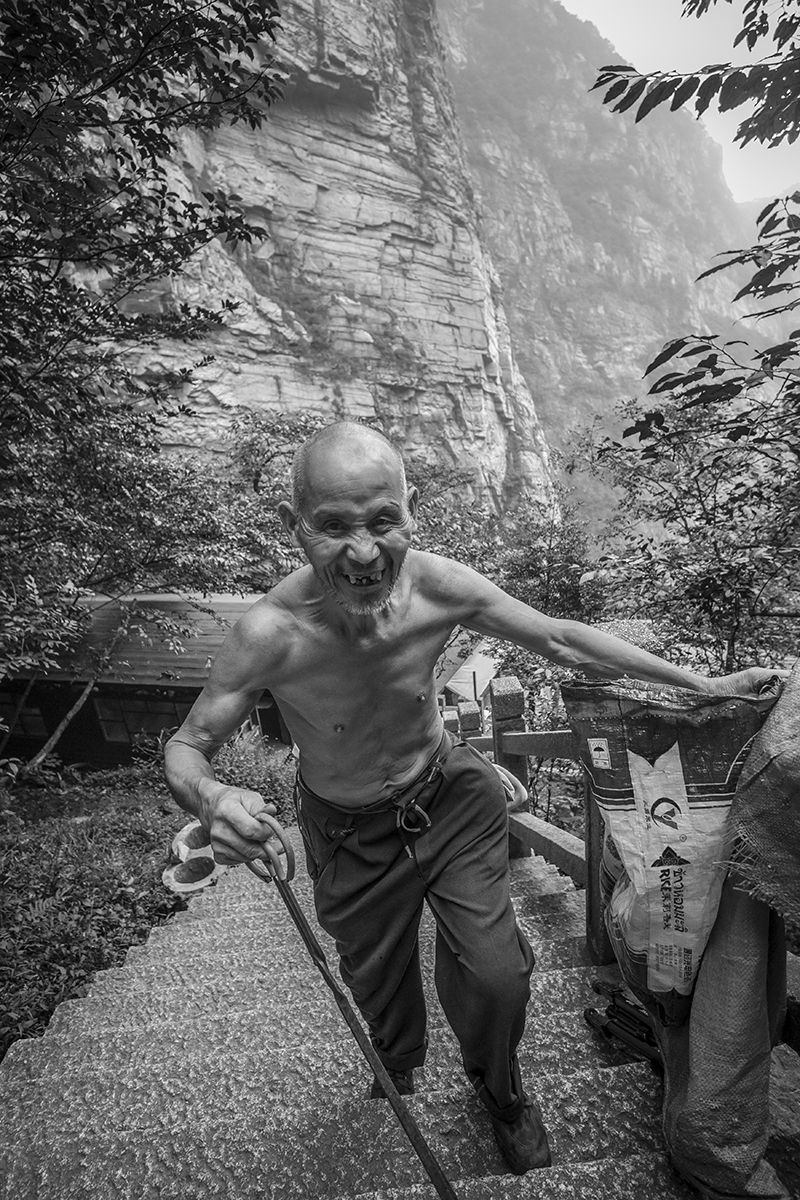 elderly man climbing mountain in china