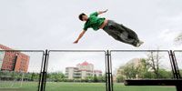 Zhangjing Shuyu launches himself over a fence at the Beijing Jiaotong University