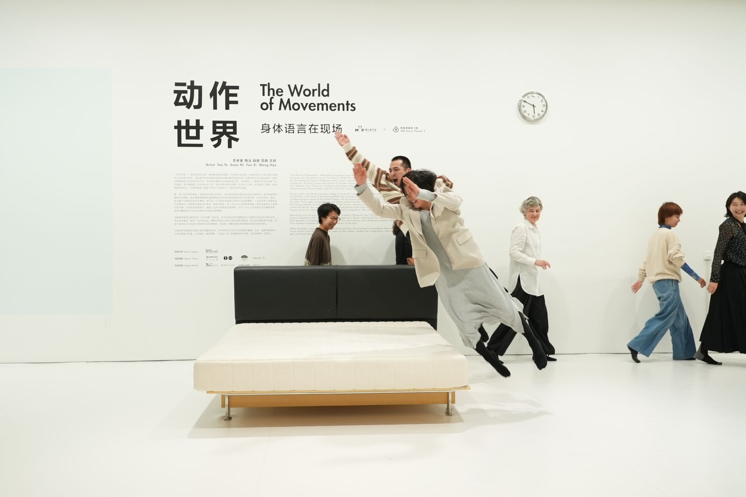 Two dancers leap on a trampoline framed by a double bed. Open to the audience, this activity encourages creative body movements.