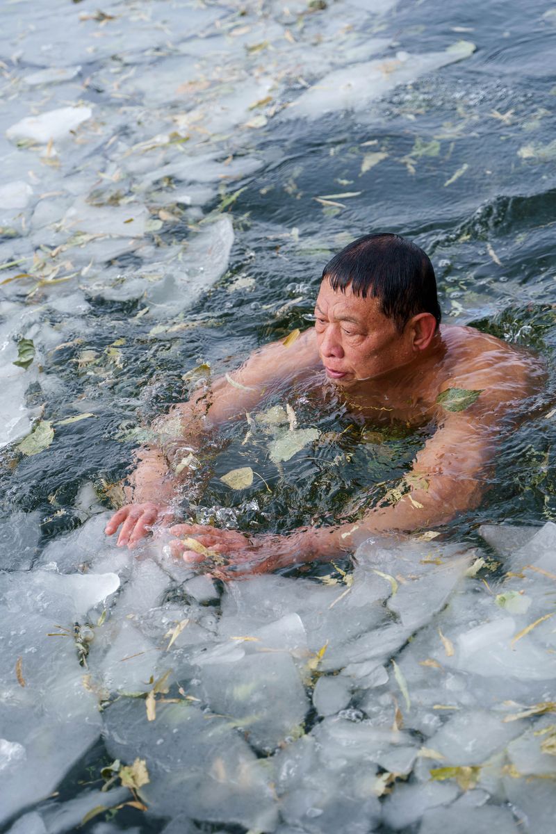 A man swimming in the iced water