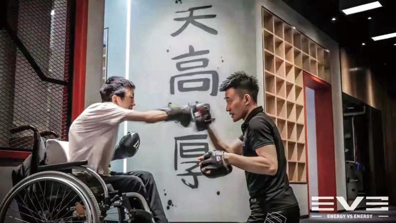 Yiming practicing boxing in a wheelchair with a coach (Yiming)