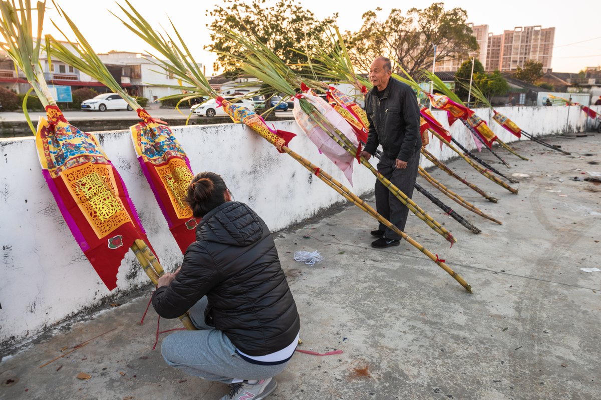 Paper money is tied to the sugarcane sticks to symbolize good luck and wealth