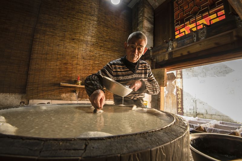 Scooping out the curds for pressing. In Heping town, Fujian province, where the workshop in these photos is located, the curdling process relied on fermentation rather than coagulants