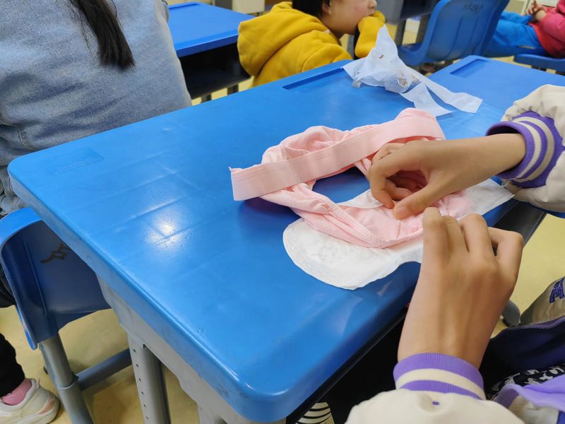 students learning to put on menstrual pads in a sex education class in China