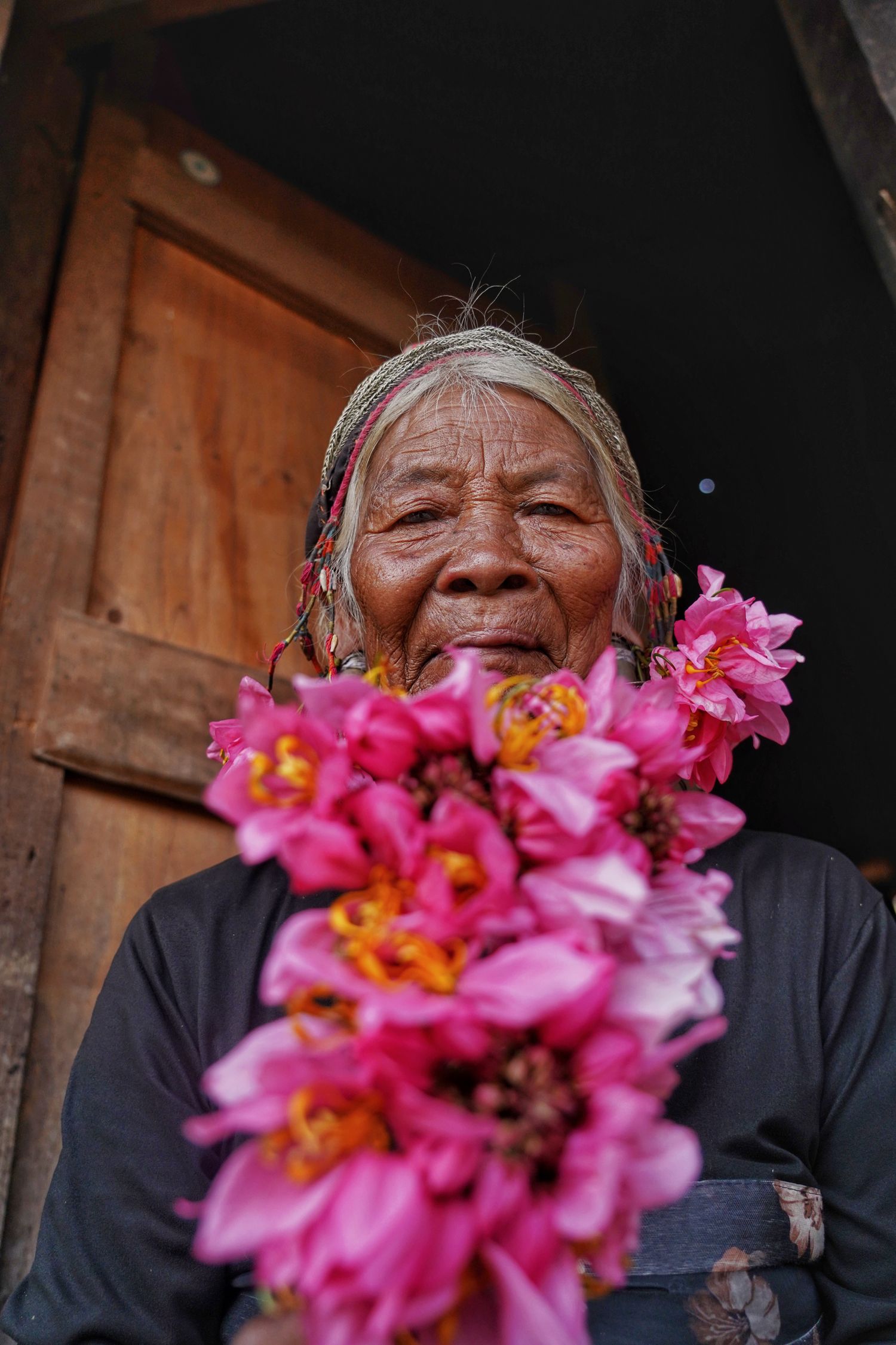 An elderly Va woman wearing a fresh flower decoration