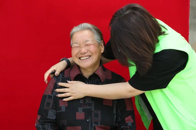 Volunteers helping Chinese granny get ready to take portrait