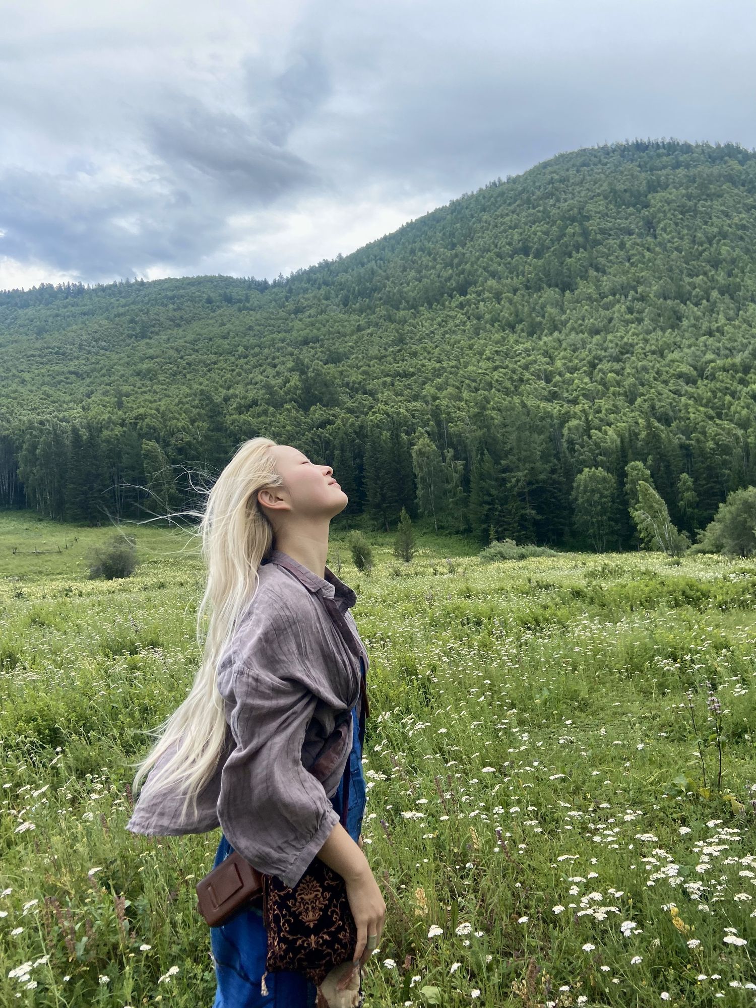 A visitor inhales the crisp mountain air amidst Altay’s natural beauty
