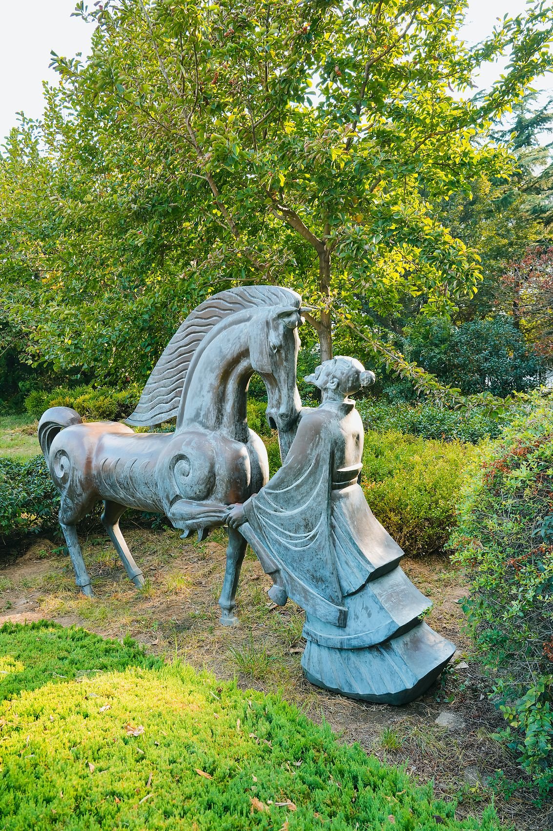 A modern sculpture of Bo Le examining a horse in a park in Qingdao, Shandong province