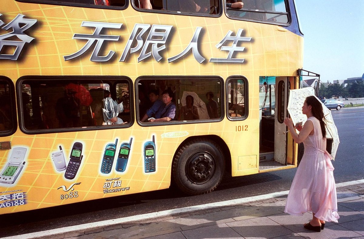 Advertisements on phones displayed on a bus in 2000 on the street of Beijing