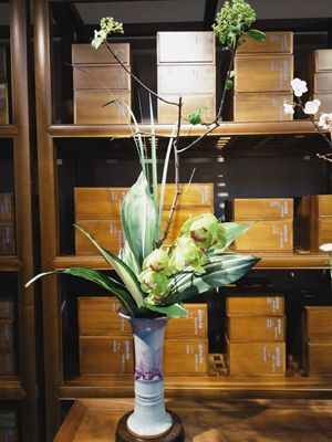 Chinese flower arrangement in white flower vase