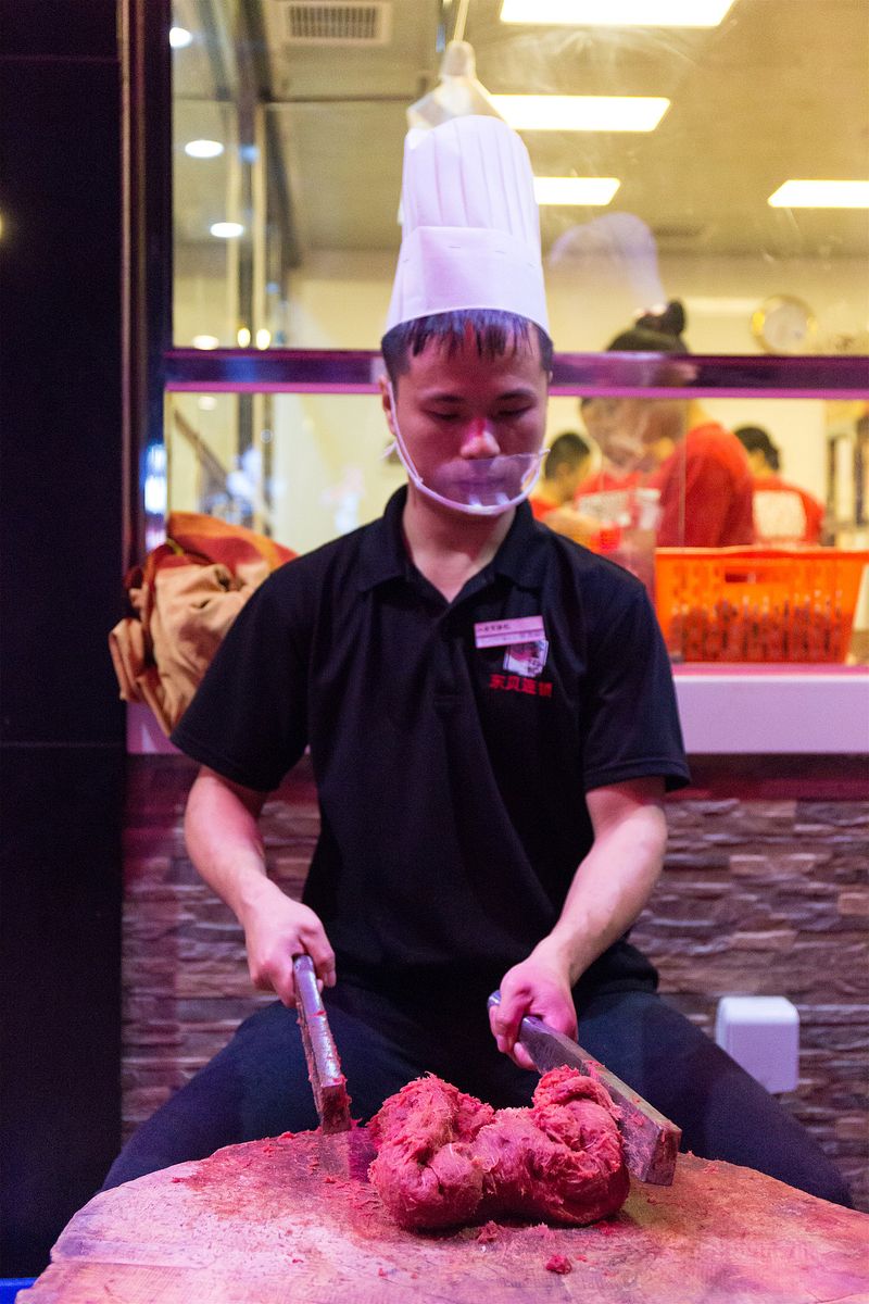 A Baheli chef performs the labor-intensive process of forming beef balls