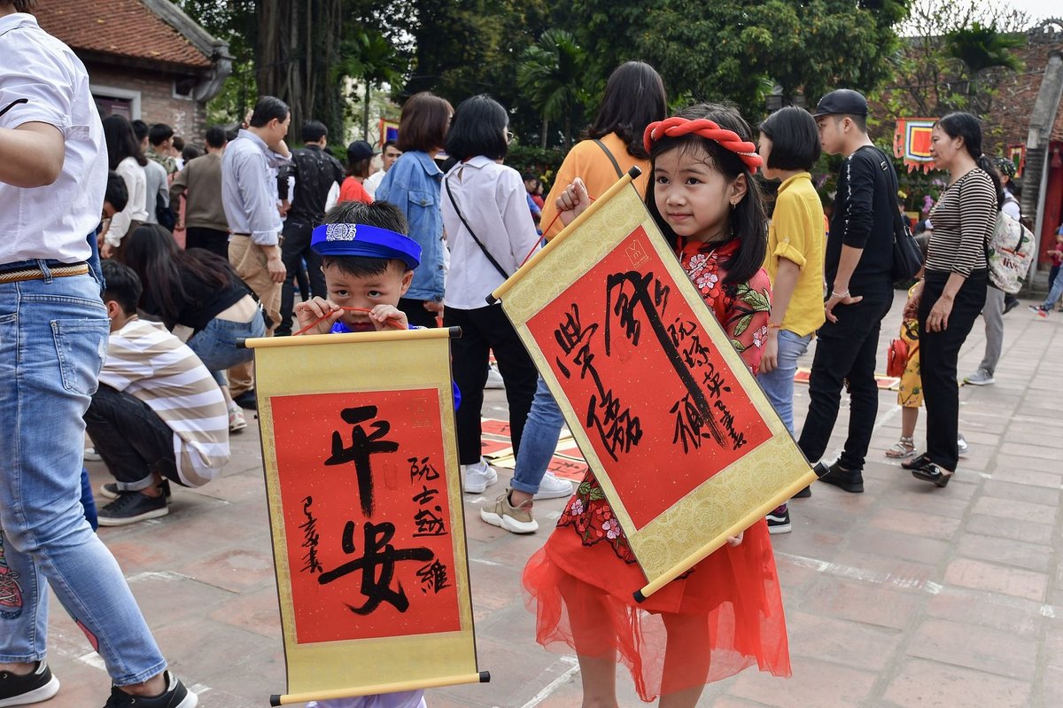 Vietnamese children wearing red clothes, visiting the Confucius Temple during the Lunar New Year to seek blessings