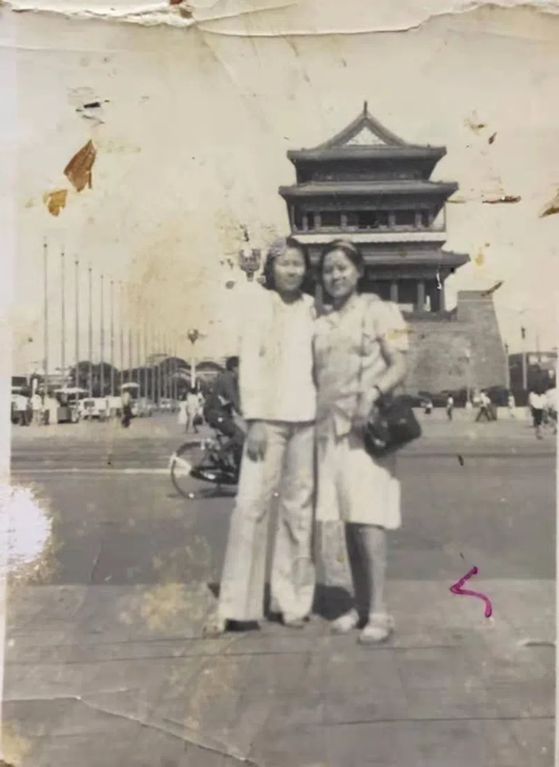 An vintage photo of the the Beijing street cleaner who moved from rural Anhui life, with a Beijing drum tower in the background.