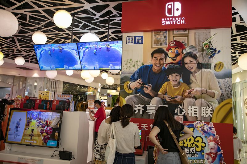 Chinese customers playing a Nintendo Switch at a Nintendo store