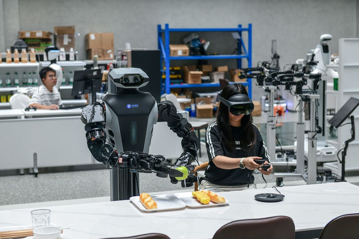 an engineer with headsets uses controllers to operate humanoid robots to grasp objects