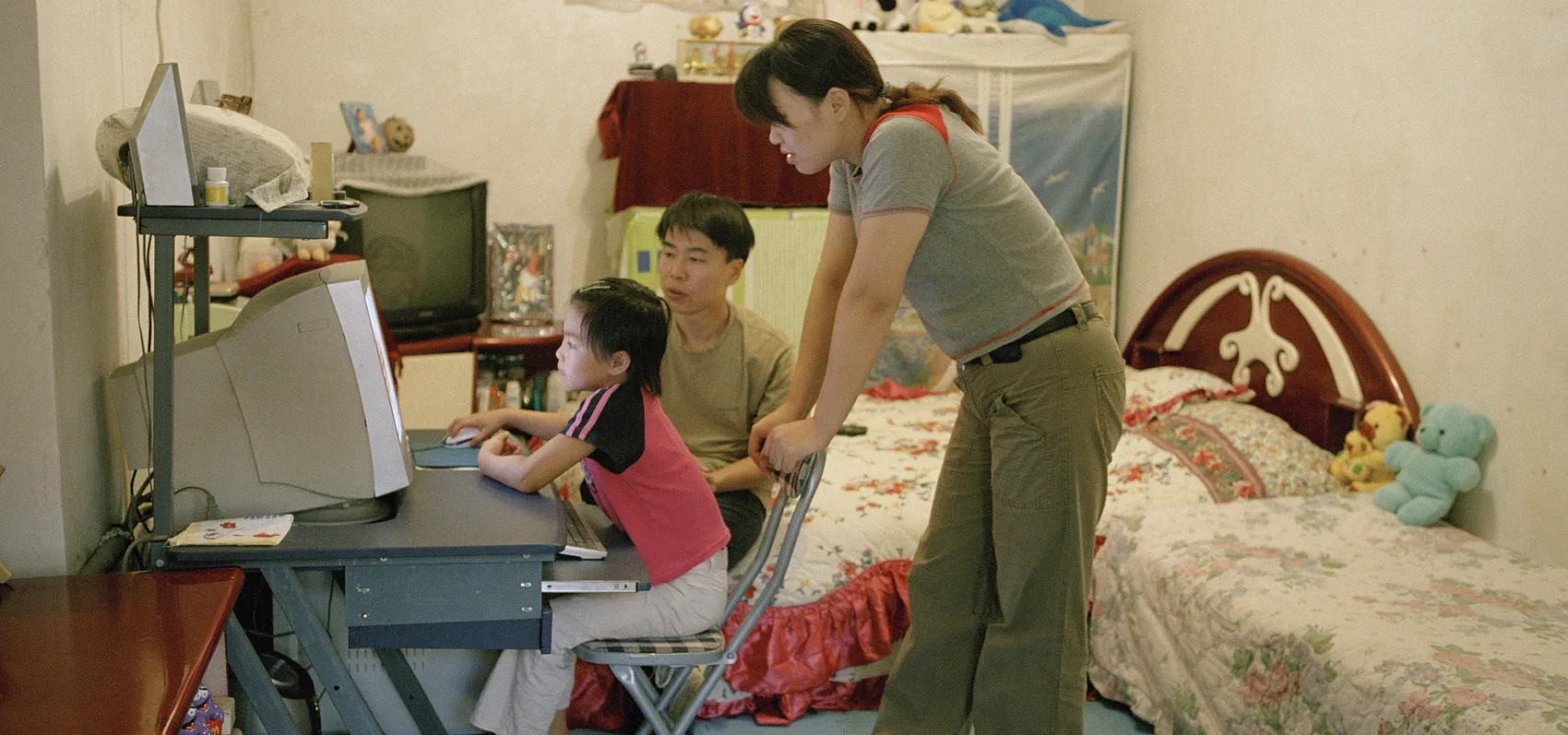 Chinese parents watching kid play computer game in Beijing_VCG31N594770664