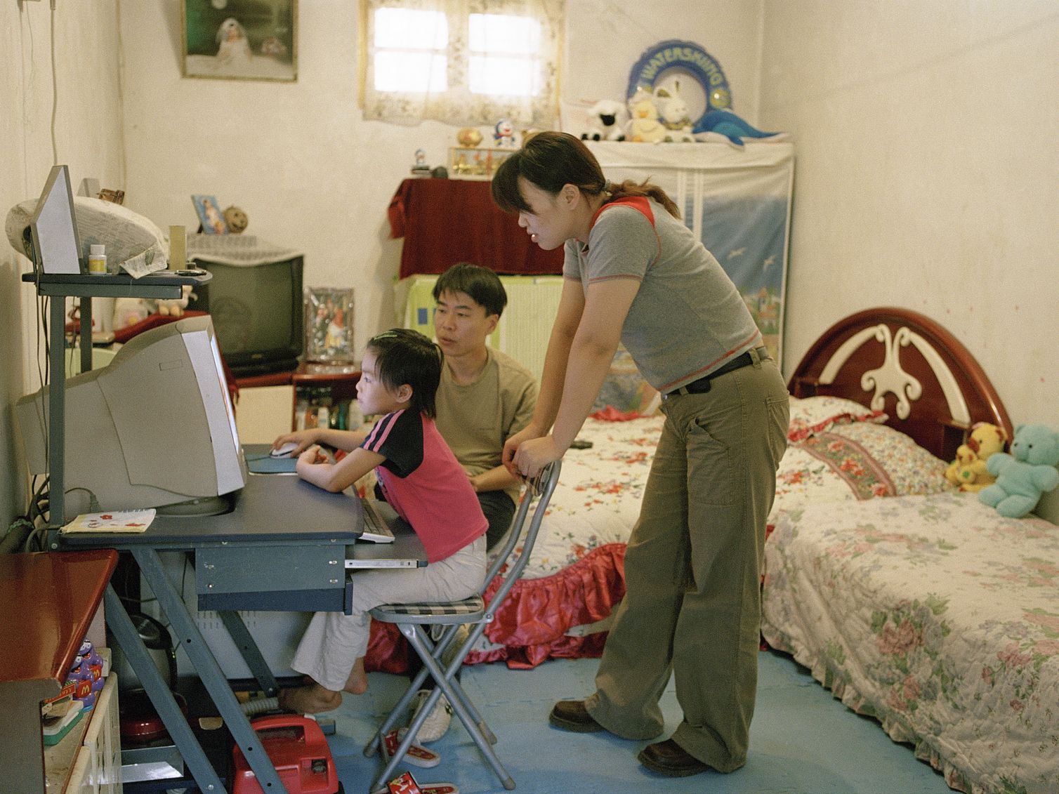 Chinese parents watching kid play computer game in Beijing_VCG31N594770664