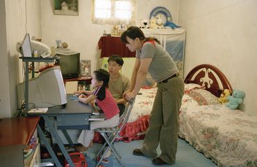 Chinese parents watching kid play computer game in Beijing_VCG31N594770664