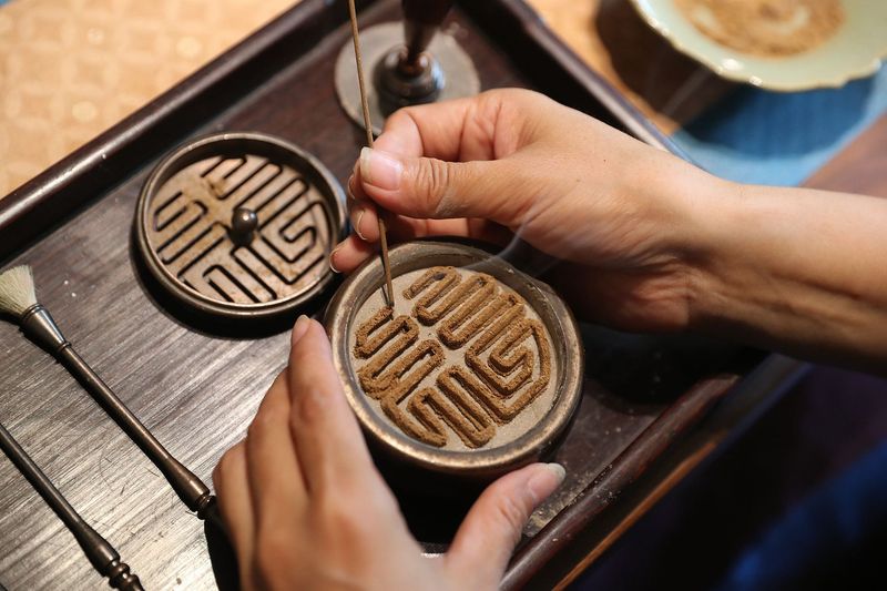 Man carving a traditional Chinese seal script incense