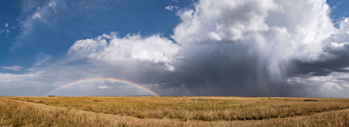 Low-angle shot of a rainbow and a storm