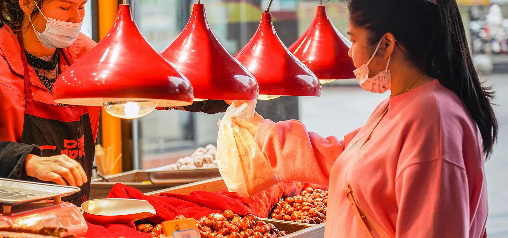 Chinese woman buying chestnuts at a stall in Wuhan