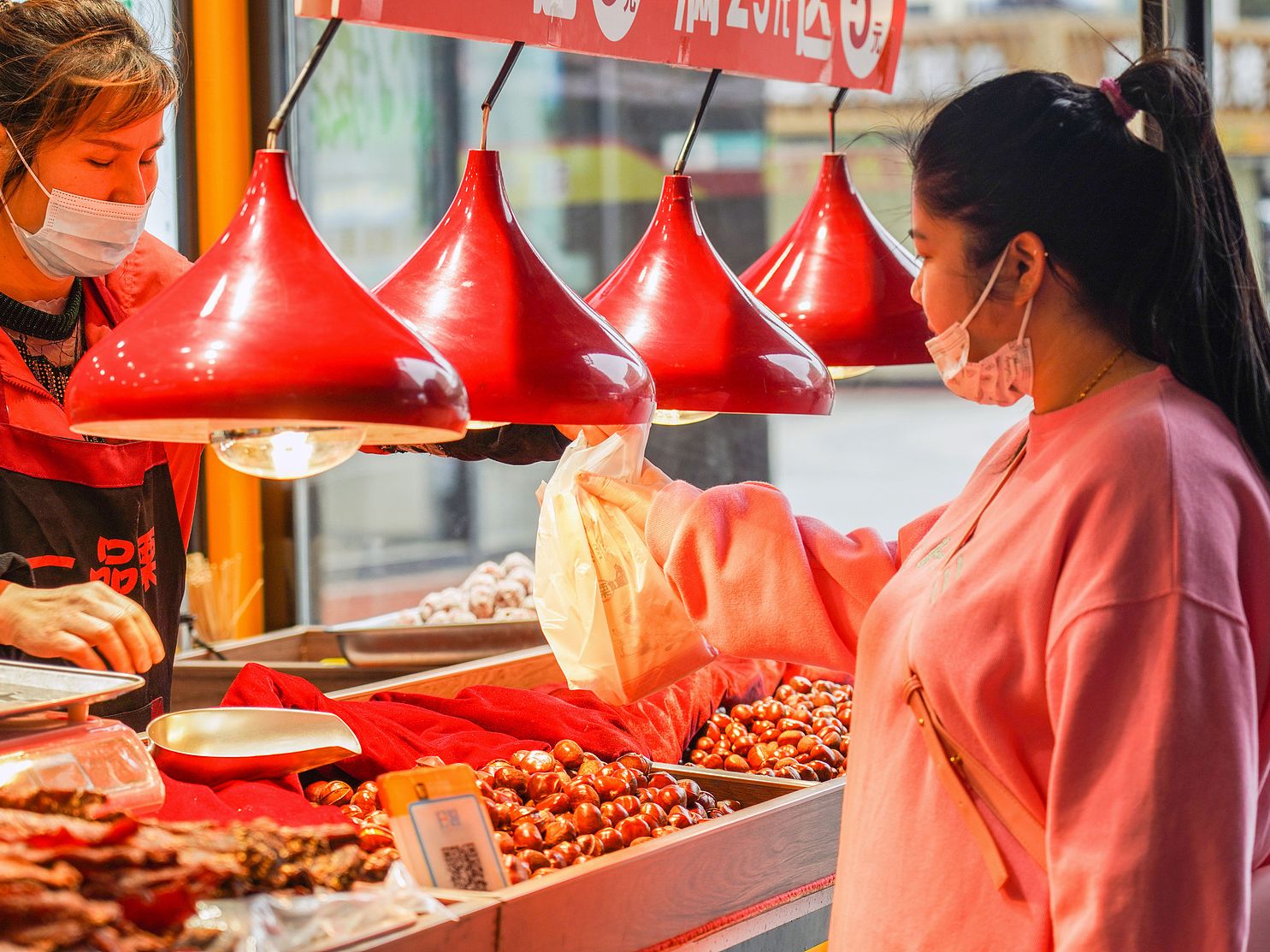 Chinese woman buying chestnuts at a stall in Wuhan