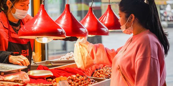 Chinese woman buying chestnuts at a stall in Wuhan