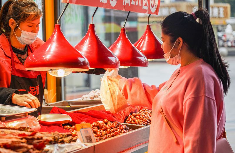 Chinese girl buying roasted chestnuts in Wuhan