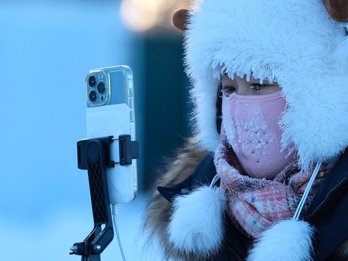 Chinese woman taking photos during winter_VCG111540818816