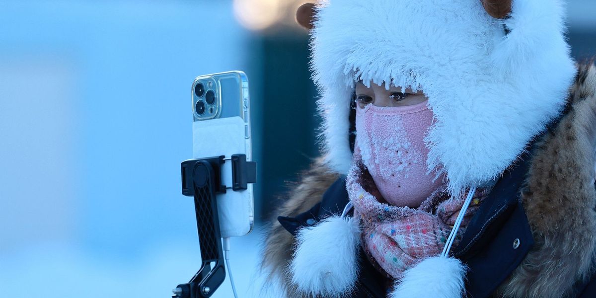 Chinese woman taking photos during winter_VCG111540818816