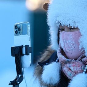 Chinese woman taking photos during winter_VCG111540818816