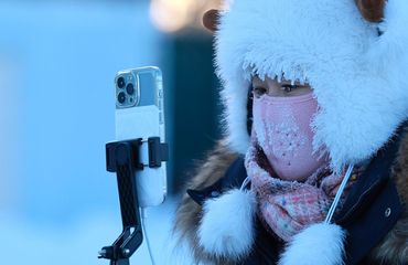 Chinese woman taking photos during winter_VCG111540818816