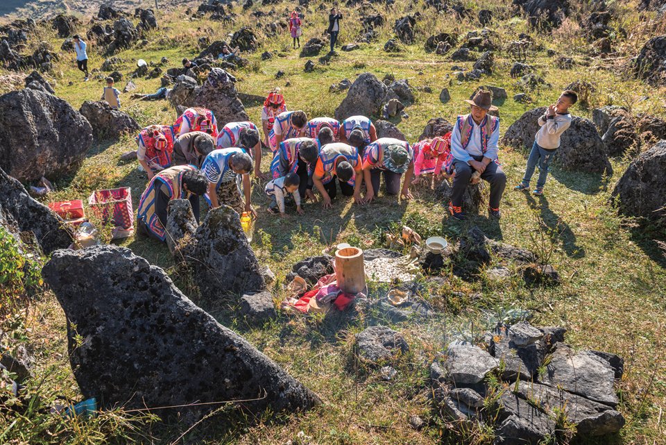 Worshipers kneel as the plates are returned to the coffin