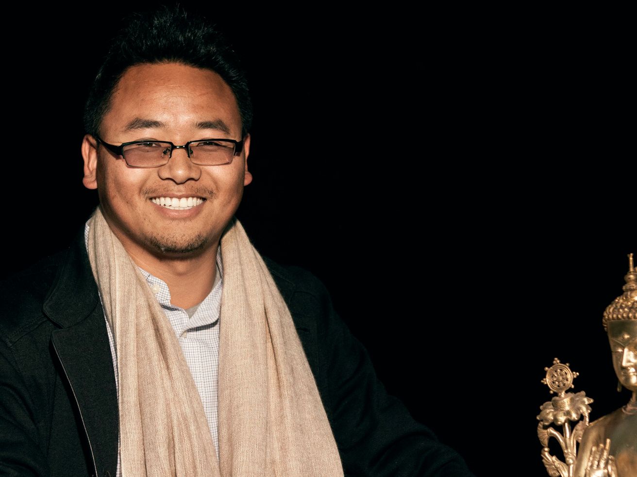 Headmaster Yeshi Tenzin with a golden Buddha