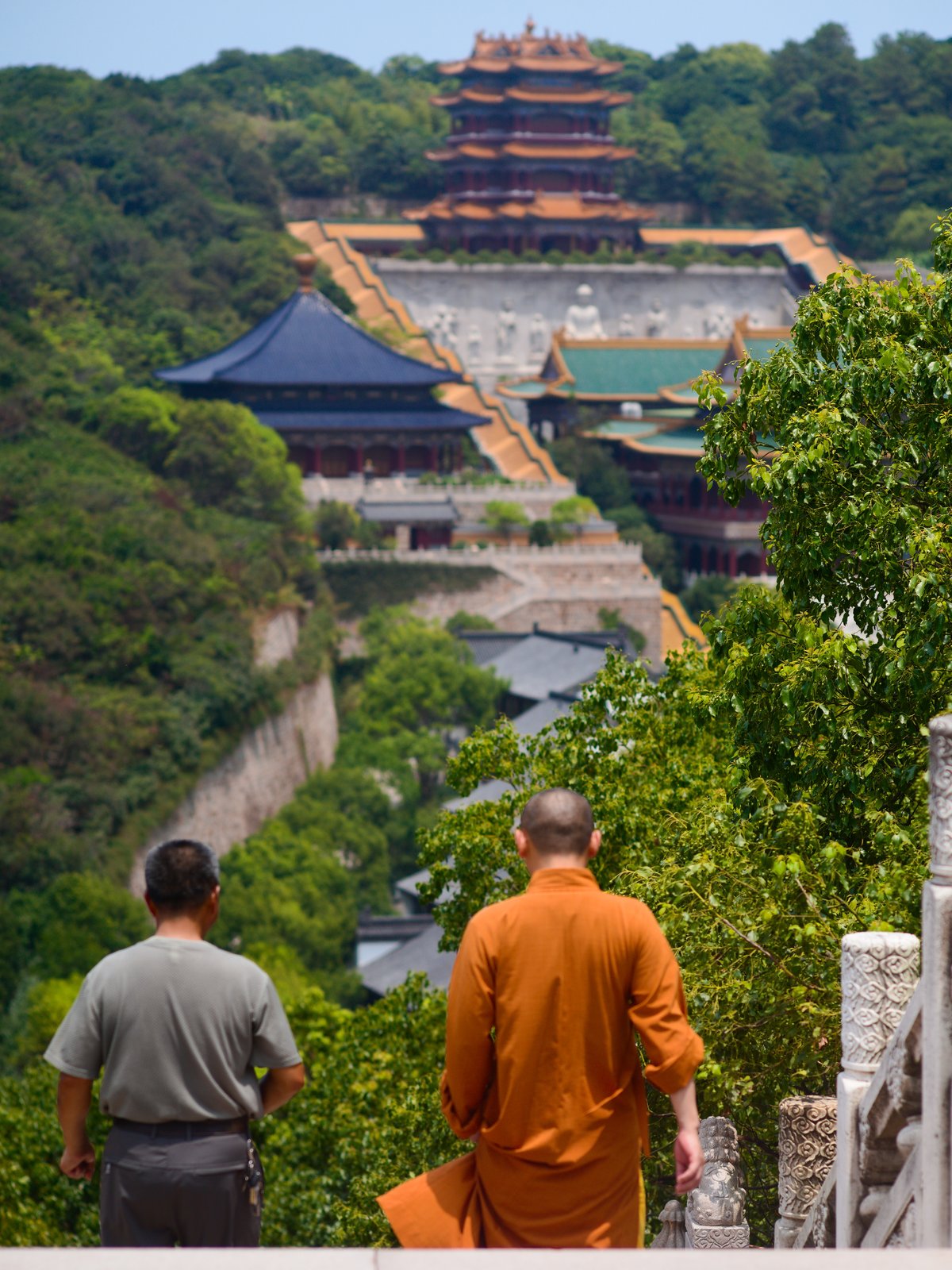 A monk accompanies a man down the stairs at Wanfobao Pagoda. Across from them is Baotuo Temple, completed in 2011, the newest on the island.