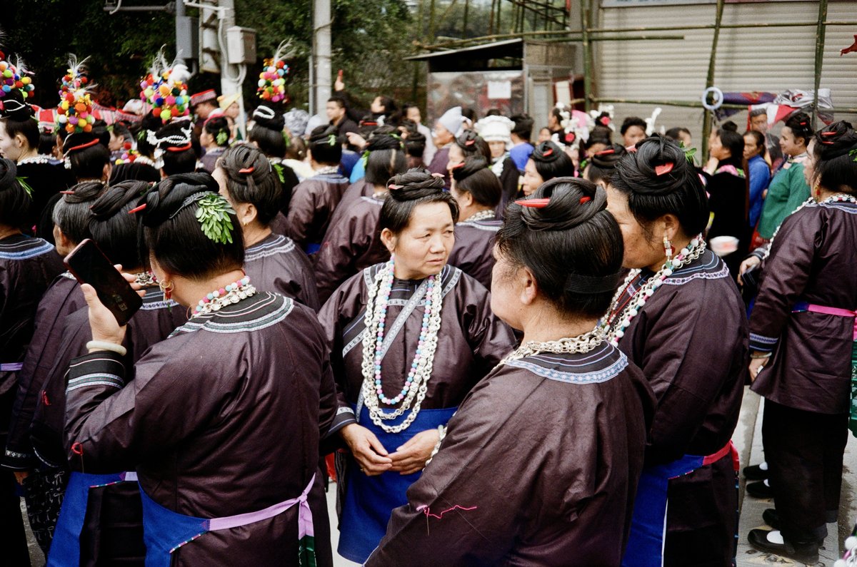 Women wearing boxwood sprigs, known as “ten-thousand-year green (万年青)” in Chinese, that represent longevity