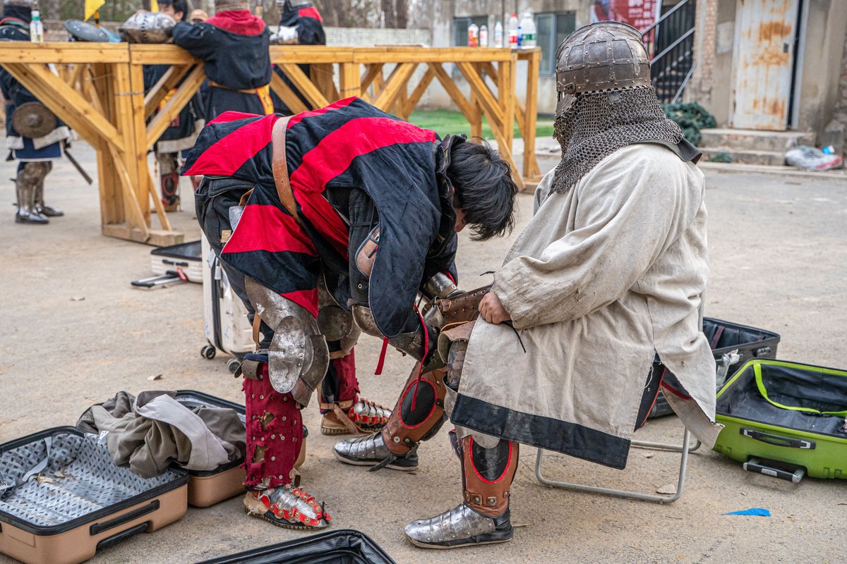 Buhurt teammates help one another put on their armor, as the various pieces are connected by straps and ties, making it difficult to suit up alone