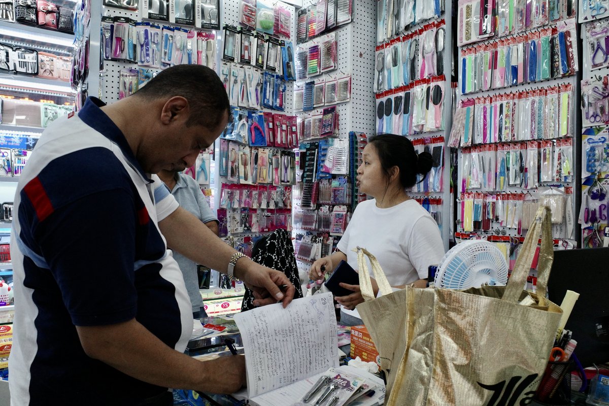 A foreign customer jotting down notes in a notebook