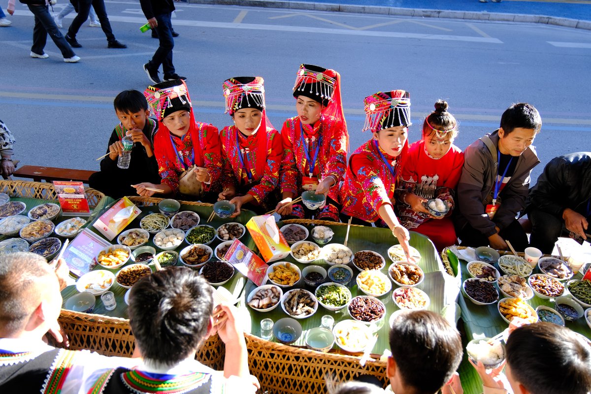 Hani minority women begin toasting guests at tables along the Long Street Banquet