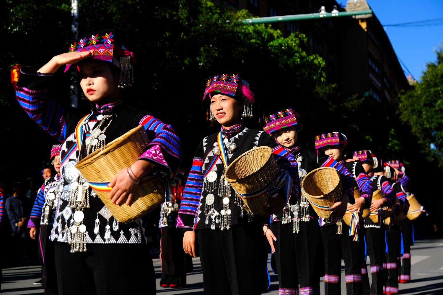 Hani women hold bamboo baskets as they showcase their elaborate Hani ethnic outfits during a parade