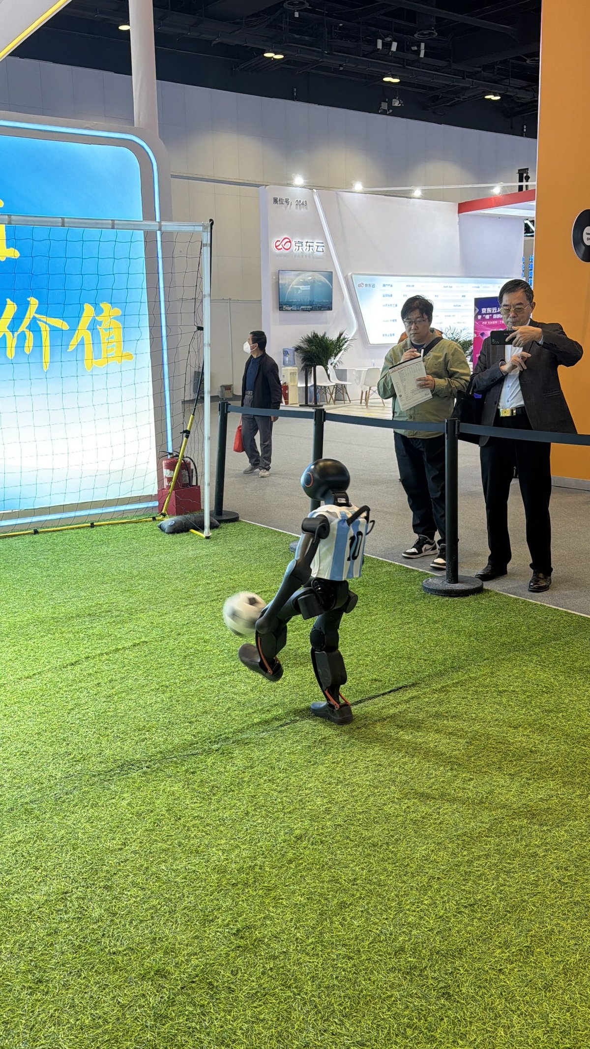 a robot kicking a football at the Beijing International High-Tech Expo, humanoid robots in China