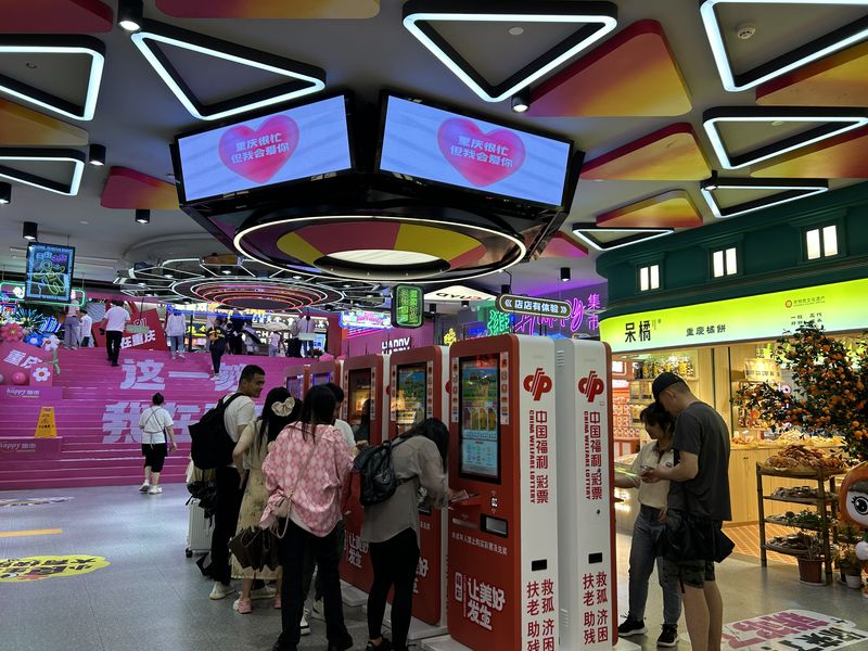 Young customers hoping to strike rich purchase lottery cards at a lottery ticket kiosk at a shopping mall in Chongqing