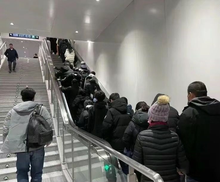 Beijing's Haidian district with many workers on an escalator wearing black down coats, China's disgusting outfits trend