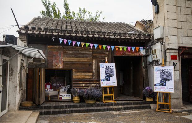 Promotional posters in front a building promote the Dashilar Short Film Festival. 