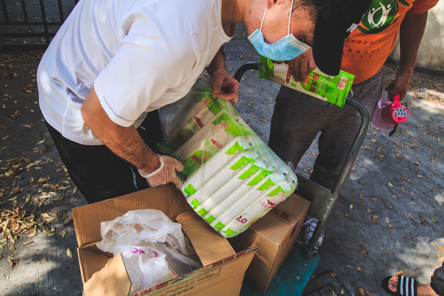 A volunteer distributes rice and noodles to residents.